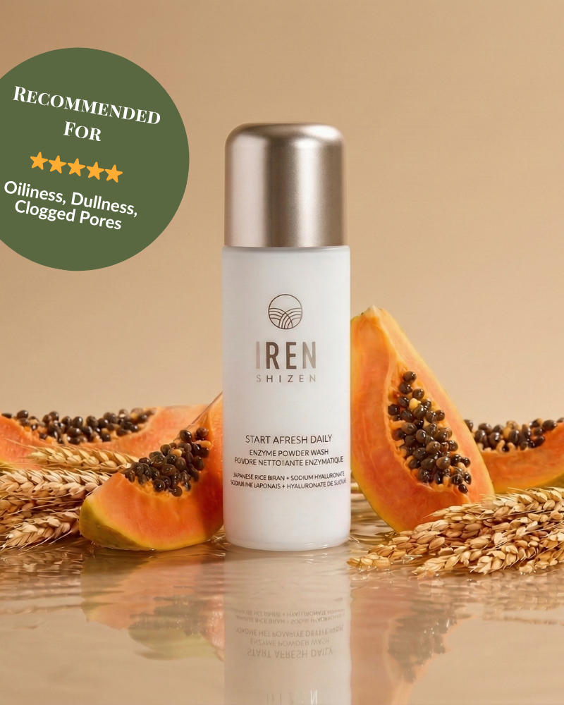 A bottle of Fast Bundle's Cloud Cleansing Kit is surrounded by papaya slices and wheat, with a green badge recommending its gentle enzyme cleanser for oiliness, dullness, and clogged pores.