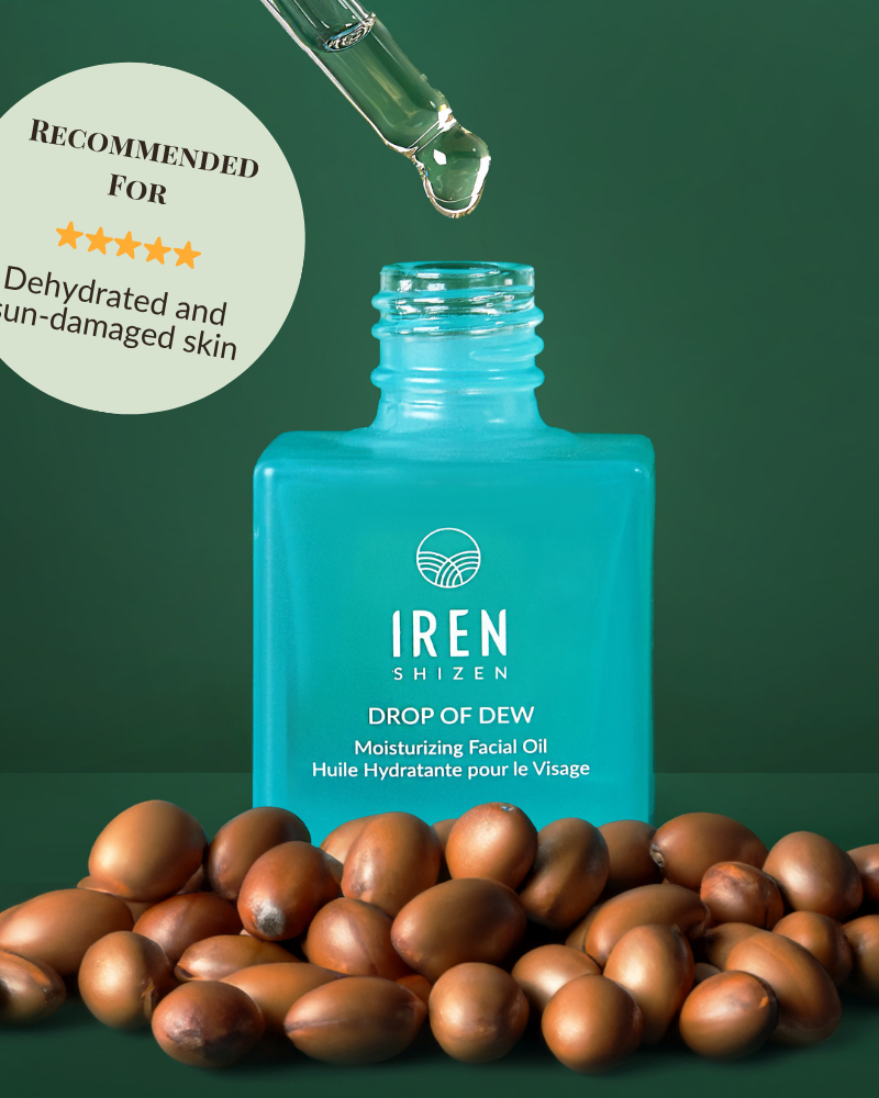 A blue bottle of IREN Shizen DROP OF DEW Moisturizing Facial Oil with a dropper above and argan nuts in front; the label highlights its recommendation for dehydrated and sun-damaged skin, supporting effective skin barrier repair.
#show-lang-en