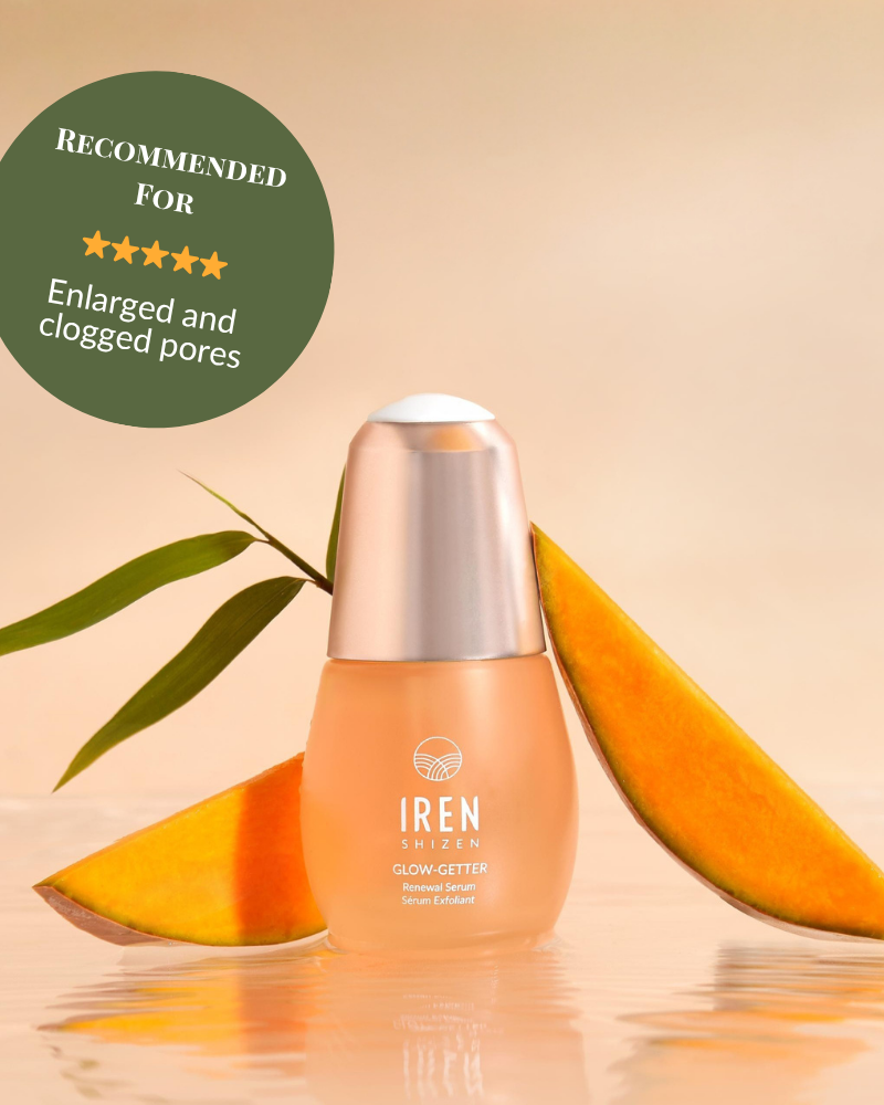 A bottle of IRÉN Shizen GLOW-GETTER Renewal Serum is shown with mango slices and a leaf, with a label recommending it to exfoliate and reduce blackheads for enlarged or clogged pores. #show-lang-en