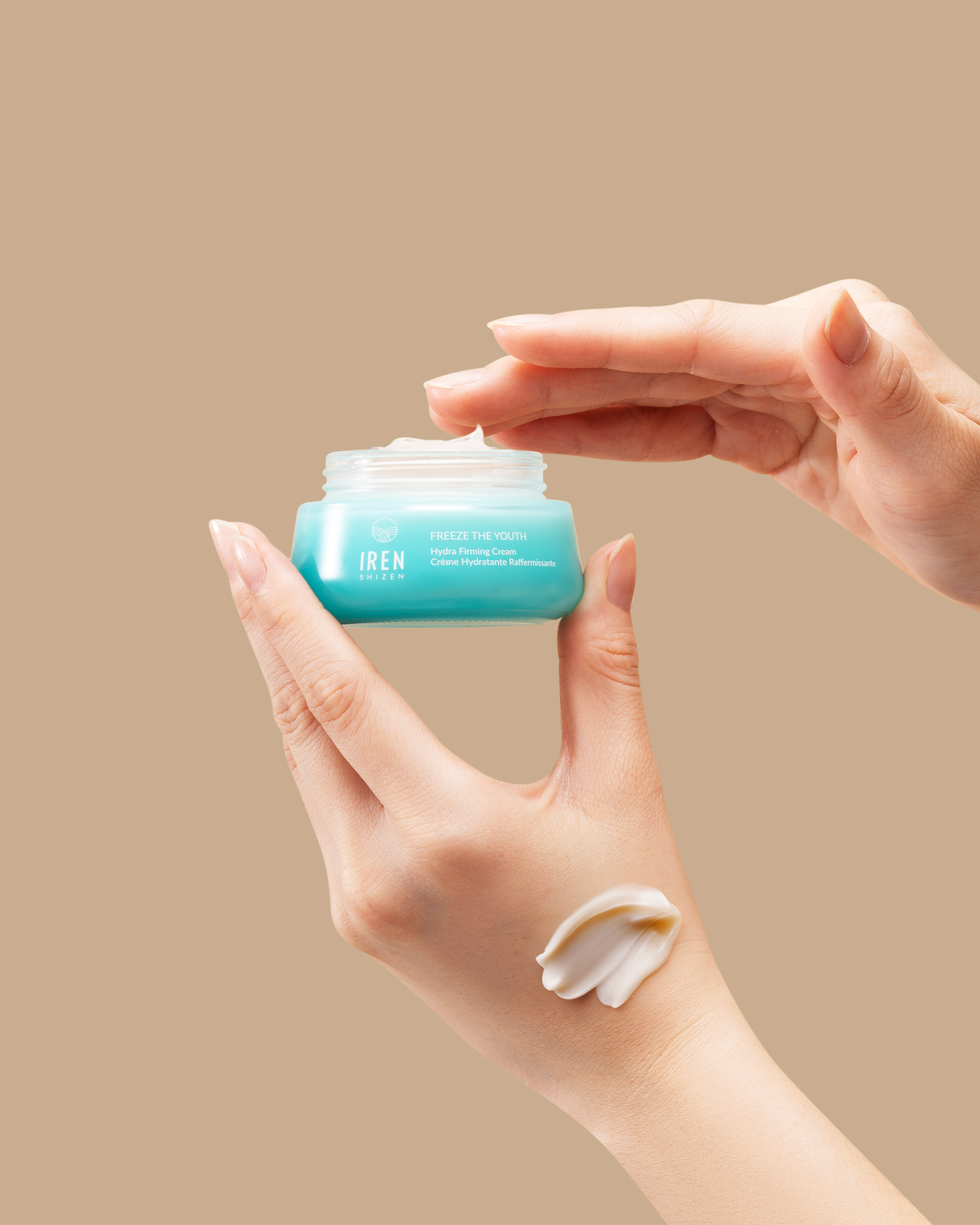 A person holding a jar of FREEZE THE YOUTH Hydra Firming Cream from IREN Shizen. #all-groups