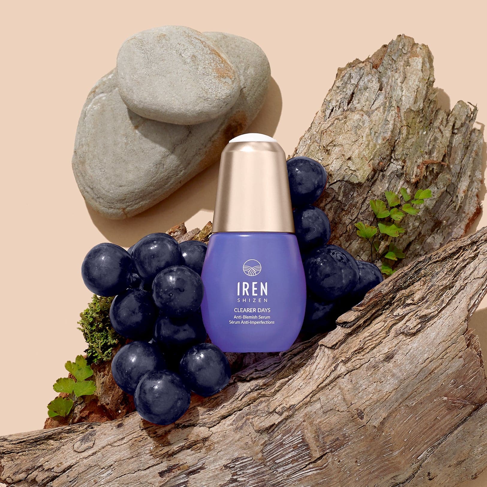 A bottle of CLEARER DAYS Anti-Blemish Serum with grapes and grapes on top of a piece of wood, showcasing Japanese skincare. #all-groups