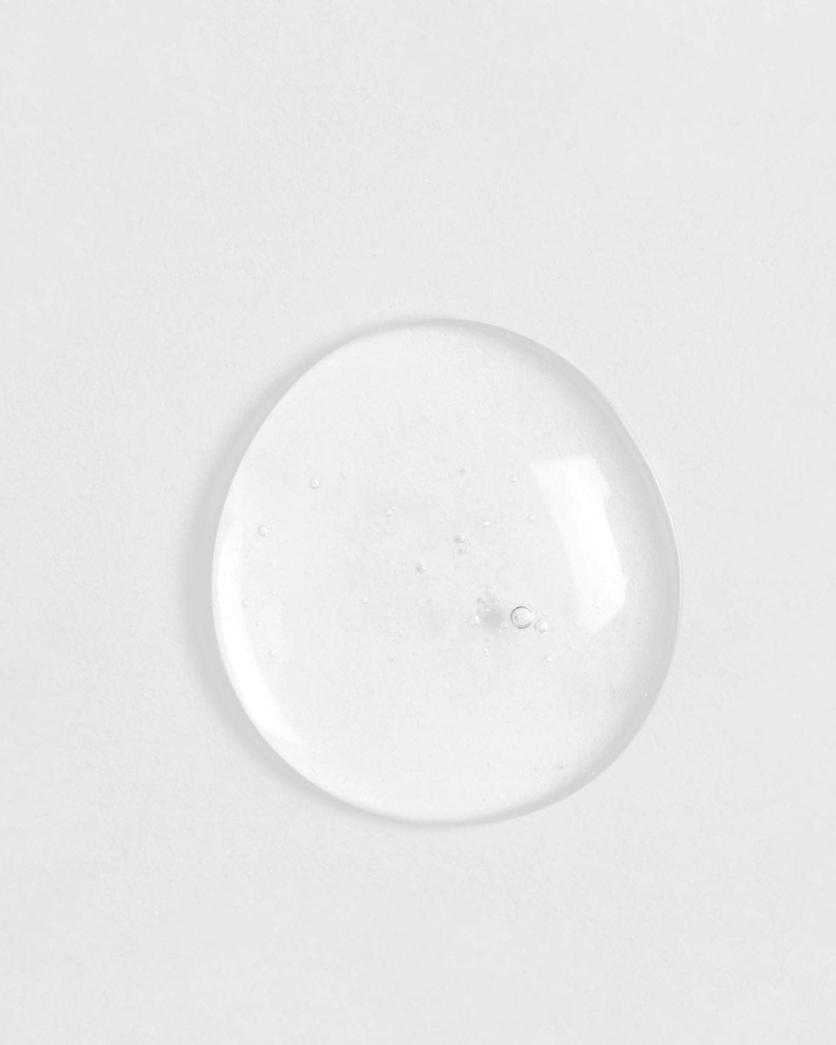 A clear glass ball of customised SKIN REBOOT Antioxidant Serum on a white surface by IREN Shizen. #all-groups