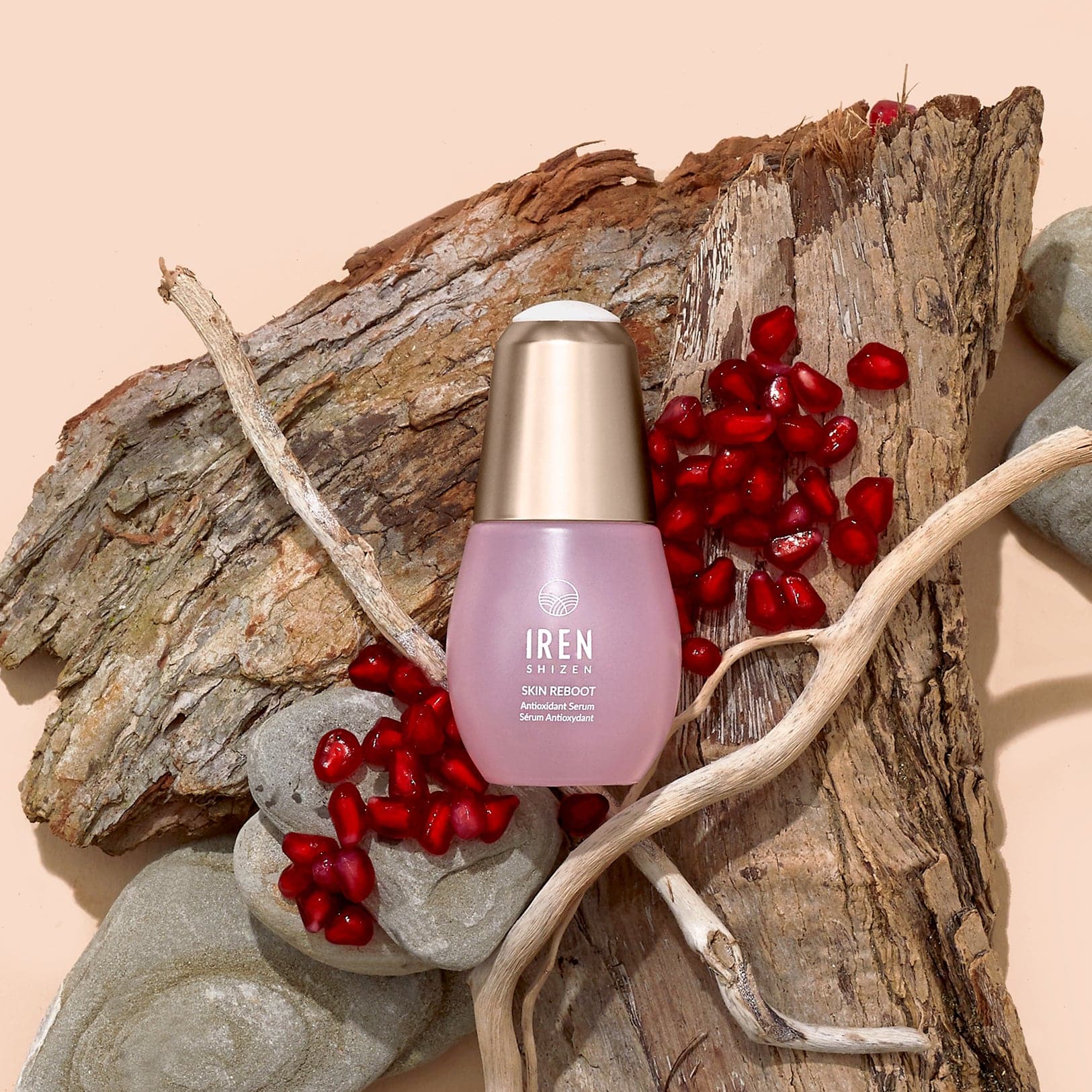 Un flacon de sérum antioxydant SKIN REBOOT personnalisé par IREN Shizen, posé sur un morceau de bois. #all-groups