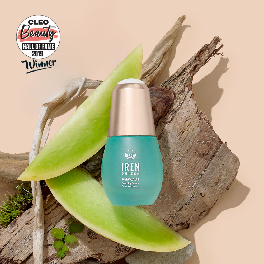 A bottle of IREN Shizen KEEP CALM Soothing Serum is placed on wood with two slices of green melon, ideal for sensitive skin. A "CLEO Beauty Hall of Fame 2019 Winner" badge appears in the top left corner.