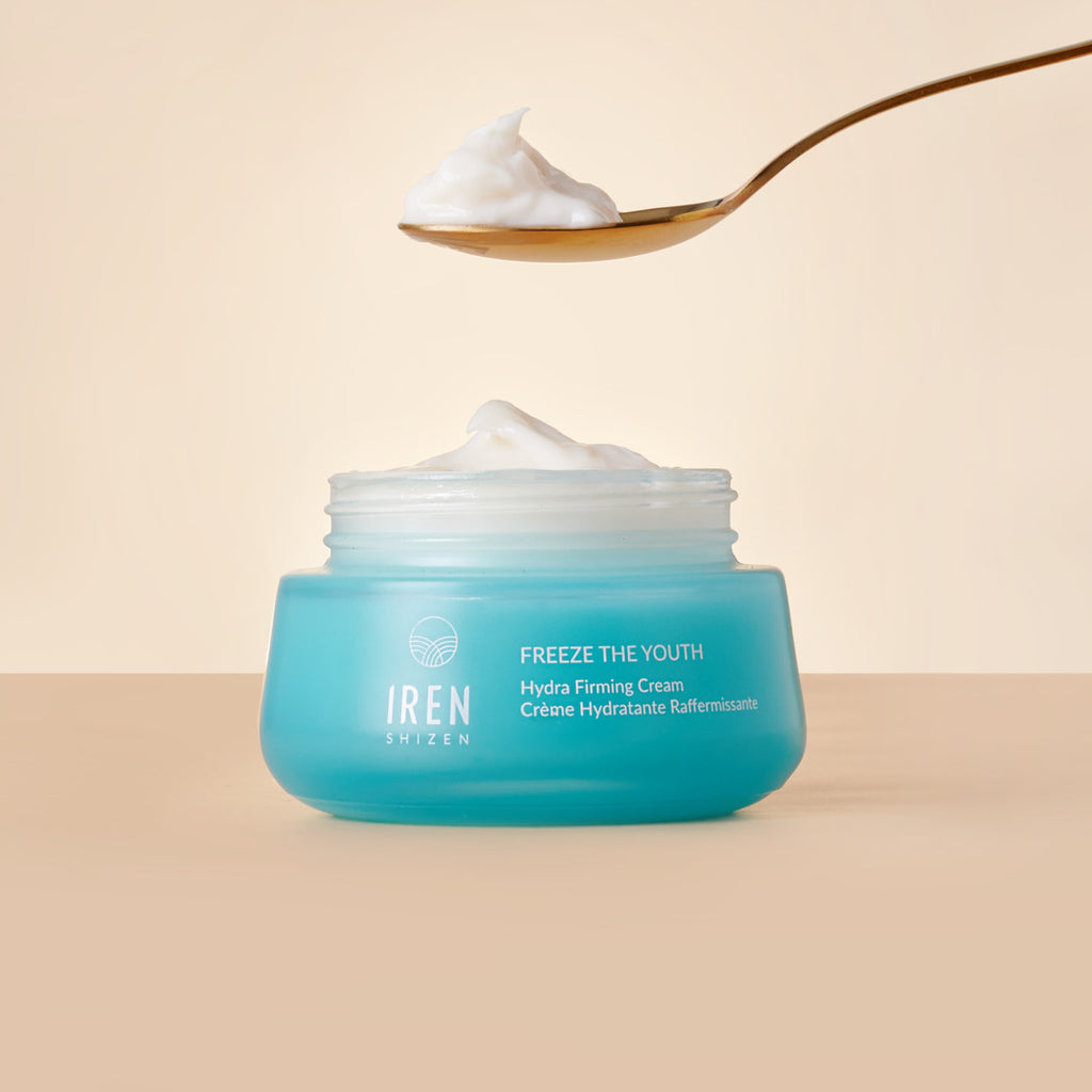A spoon hovering above an open turquoise jar labeled "MOCHI SKIN Instant Glow Set" against a pale background.