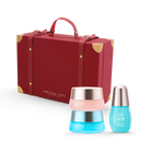 A festive red gift box with gold corners sits elegantly beside the CUSTOM XMAS For Beloved Ones Moisture Sandwich Gift Set by IREN Shizen. The lineup includes vibrant pink, blue, and turquoise containers, each housing a rejuvenating serum to pamper your skin.