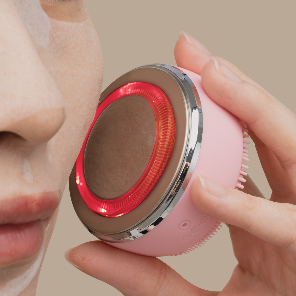 A customizable spa day for self-care, where a woman's face glows with the soothing red light treatment using the PRO MINI Skin Genie Pro + Discovery Kit from IREN Shizen.
