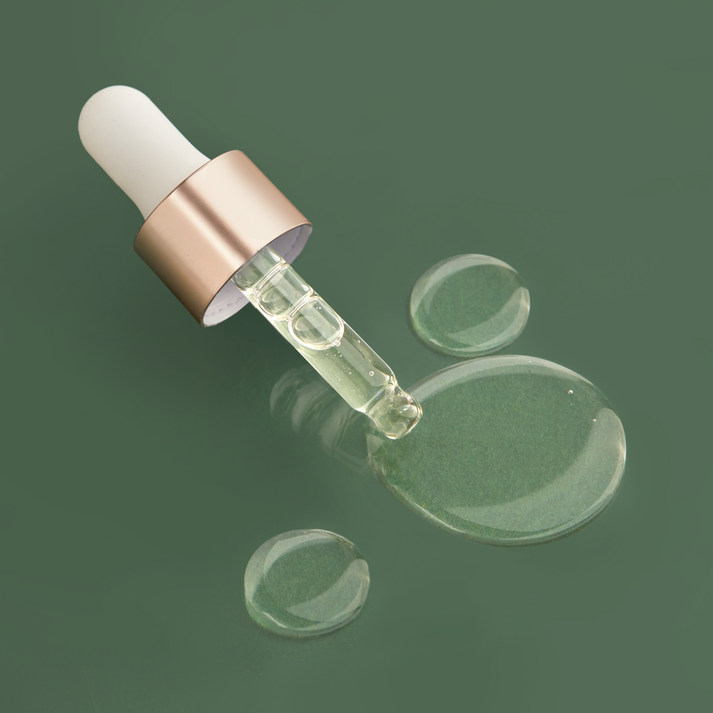 An IREN Shizen glass bottle with a DROP OF DEW Moisturizing Facial Oil on a green surface, showcasing Japanese skincare.