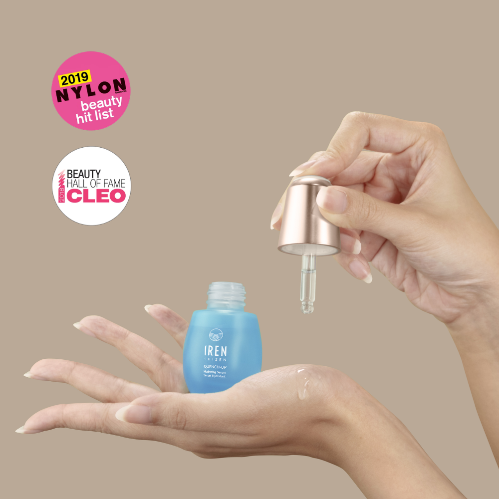 A hand dispenses QUENCH-UP Hydrating Serum from an IREN Shizen dropper bottle onto another hand. Nylon Beauty Hit List 2019 and Cleo Beauty Hall of Fame badges spotlight this plump skin hero.