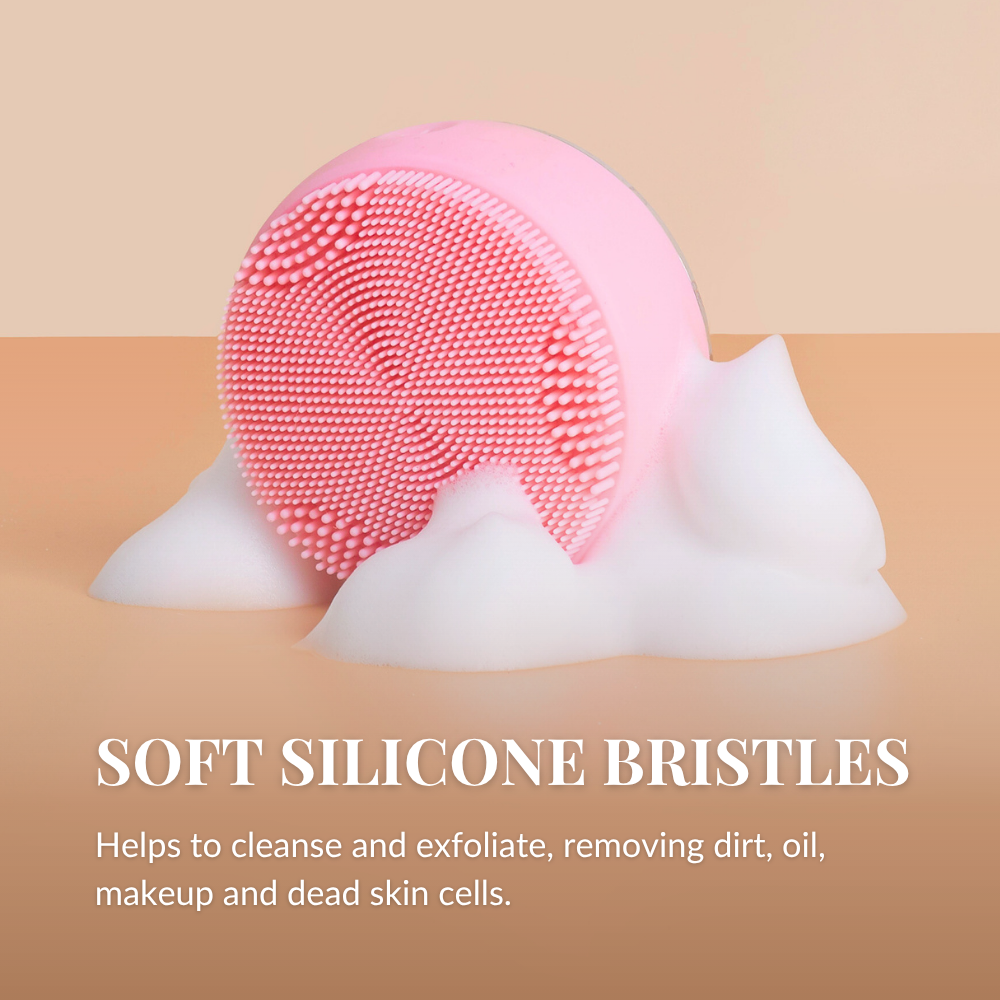 The IREN Shizen SKIN GENIE PRO Cleansing Brush + LED Light Therapy in pink rests on foamy soap atop a beige surface, highlighting its gentle exfoliation and optional LED light features for enhanced skincare.