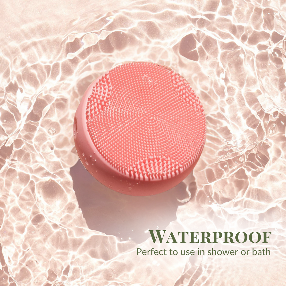 The pink SKIN GENIE PRO Cleansing Brush + LED Light Therapy by IREN Shizen floats on water, with text in the bottom right corner: "Waterproof, perfect to use in shower or bath.