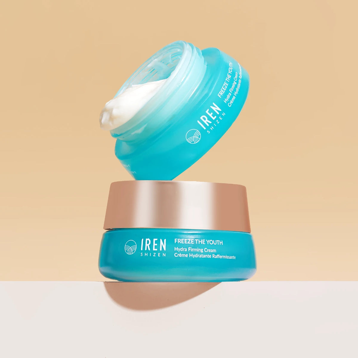 Two stacked teal jars of TIME REBOUND Lift and Firm Kit face cream, one open with a scoop of white cream visible.