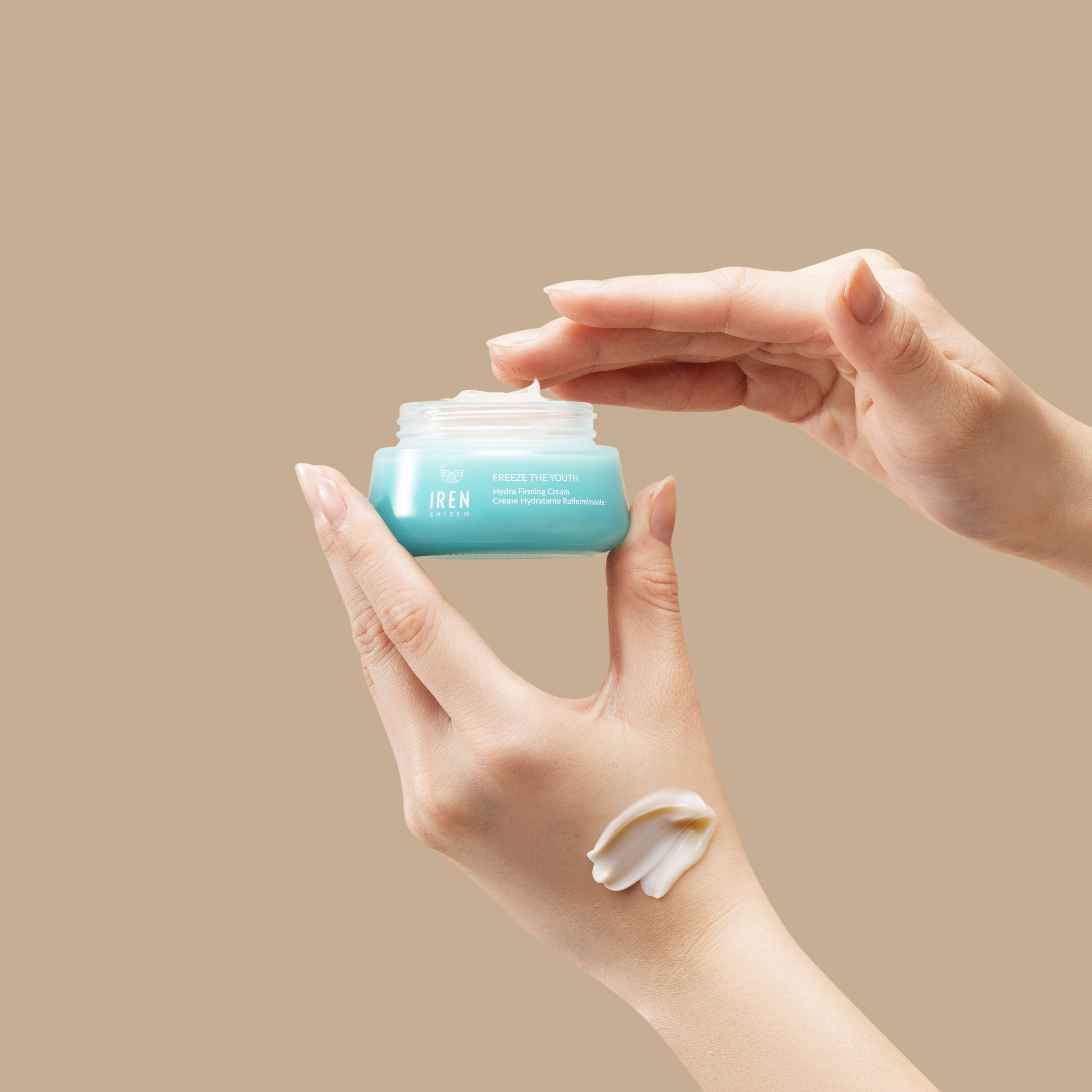 A person holding a jar of FREEZE THE YOUTH Hydra Firming Cream from IREN Shizen. all-groups