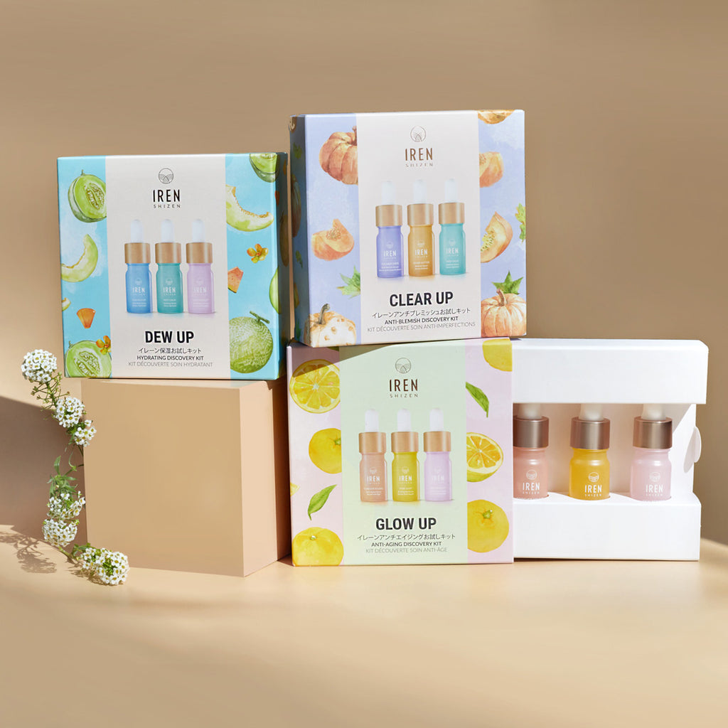 Three boxes with a variety of IREN Shizen's customized skincare GLOW UP Anti-Aging Discovery Kits on them.