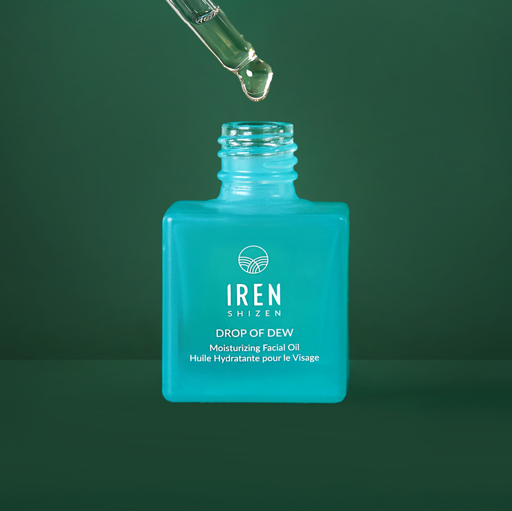 A bottle of IREN Shizen's MICROBIOME REPAIR pre and Postbiotic Facial Oils, a moisturizing facial oil, is being poured onto a green background.