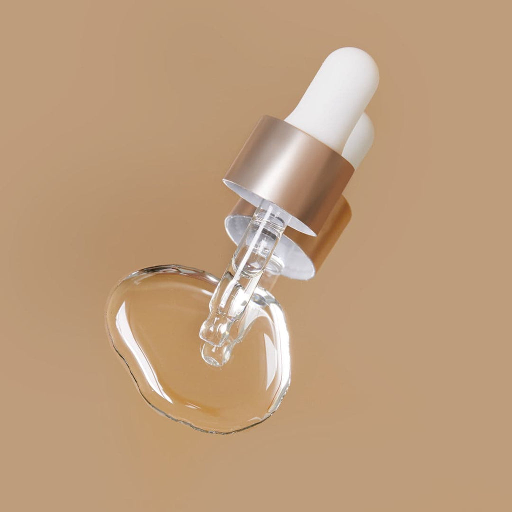 A clear glass bottle of BEST SUSTAINABLE DUO By L'OFFICIEL Beauty Awards 2023 facial oil on a beige background, by IREN Shizen.