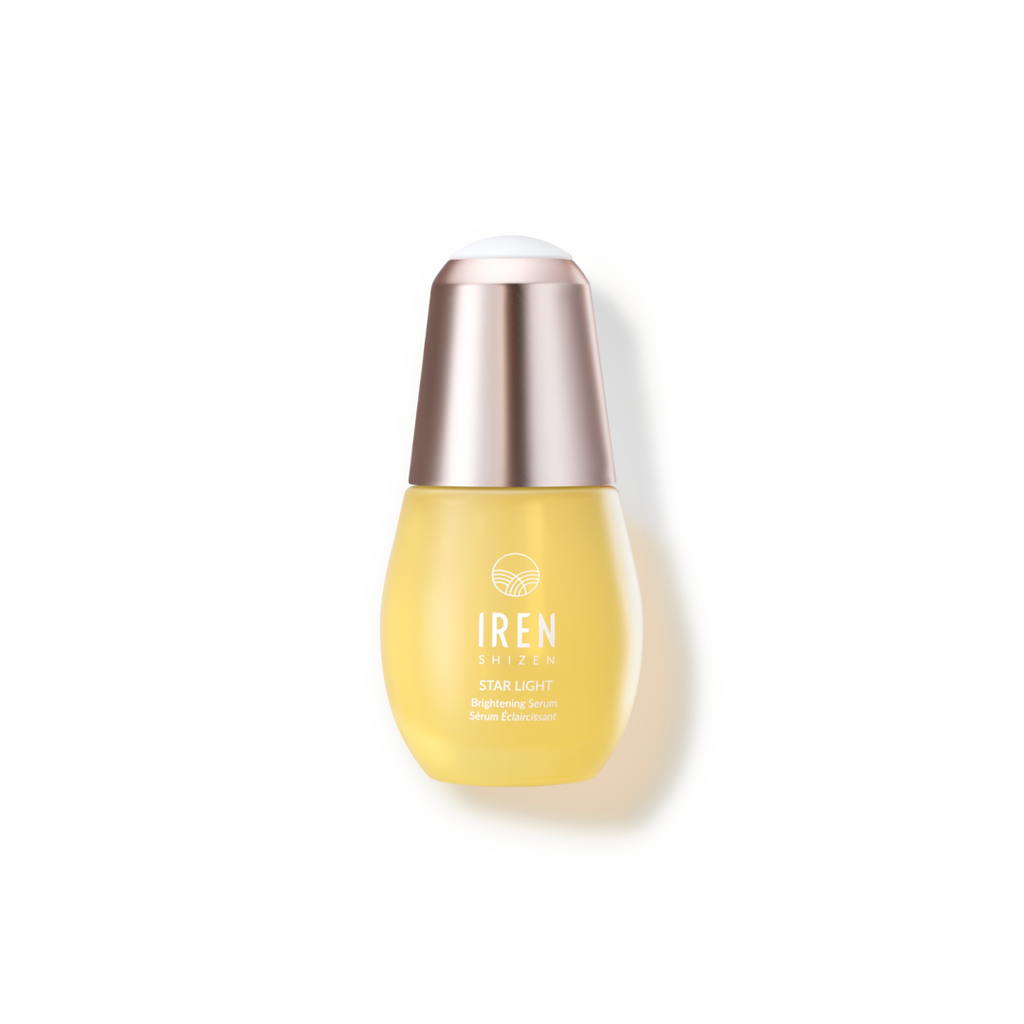 A bottle of Japanese skincare STAR LIGHT Brightening Serum by IREN Shizen on a black background.