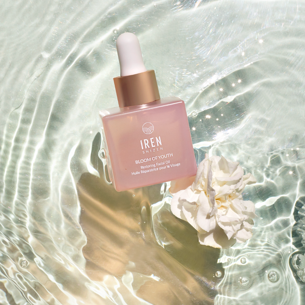 A bottle of MICROBIOME REPAIR Pre and Postbiotic Facial Oils, a facial oil known for its moisturizing properties, delicately resting on top of water.
