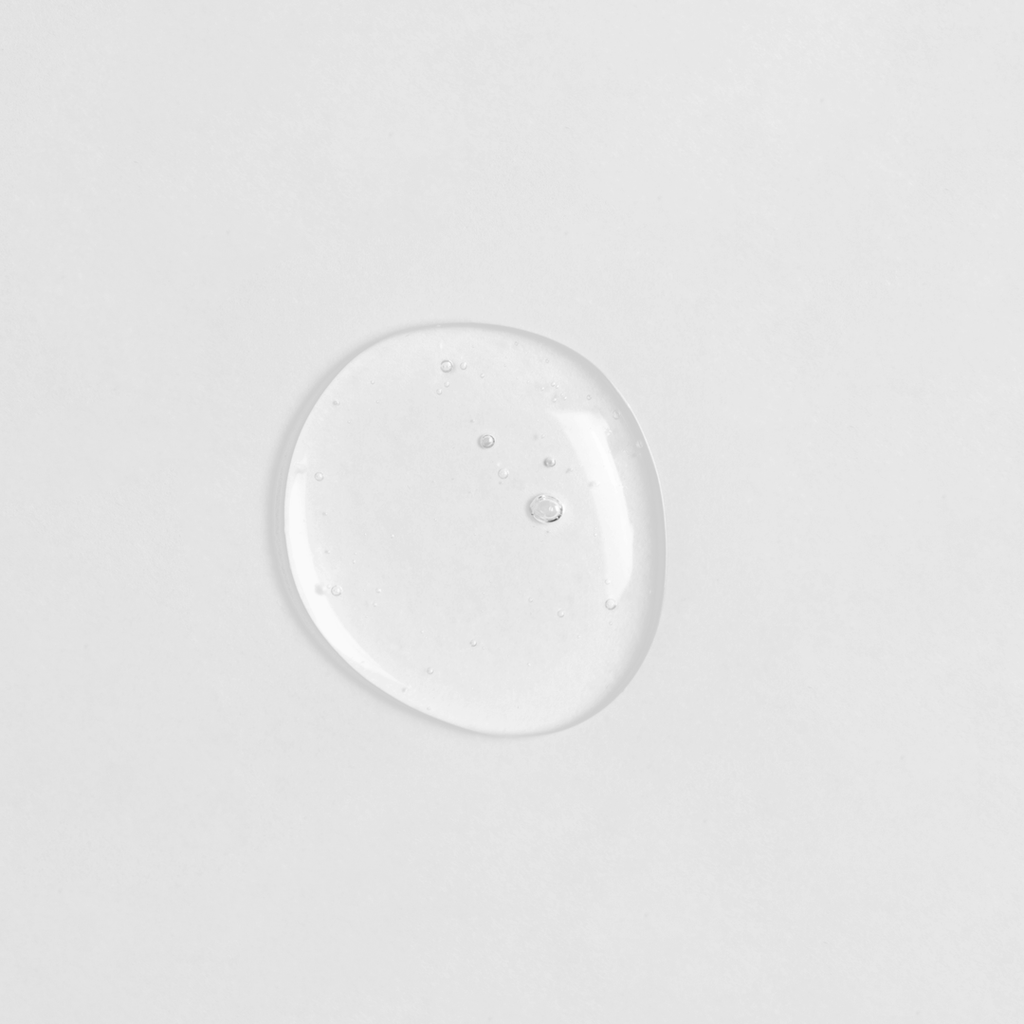 A small drop of CLEAR UP Anti-Blemish Discovery Kit on an IREN Shizen white surface, showcasing Japanese skincare.