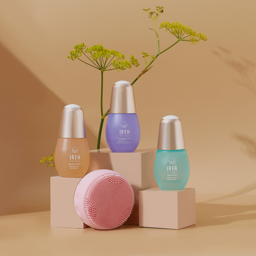 A set of customized Japanese skincare, the CLEAR UP PRO Skin Genie Pro + Anti-Blemish Sets by IREN Shizen, displayed on a table next to a plant.