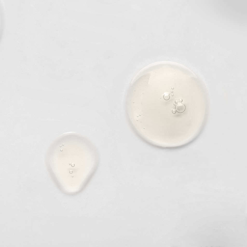 A white plate with a few drops of Japanese skincare liquid on it from the brand IREN Shizen.