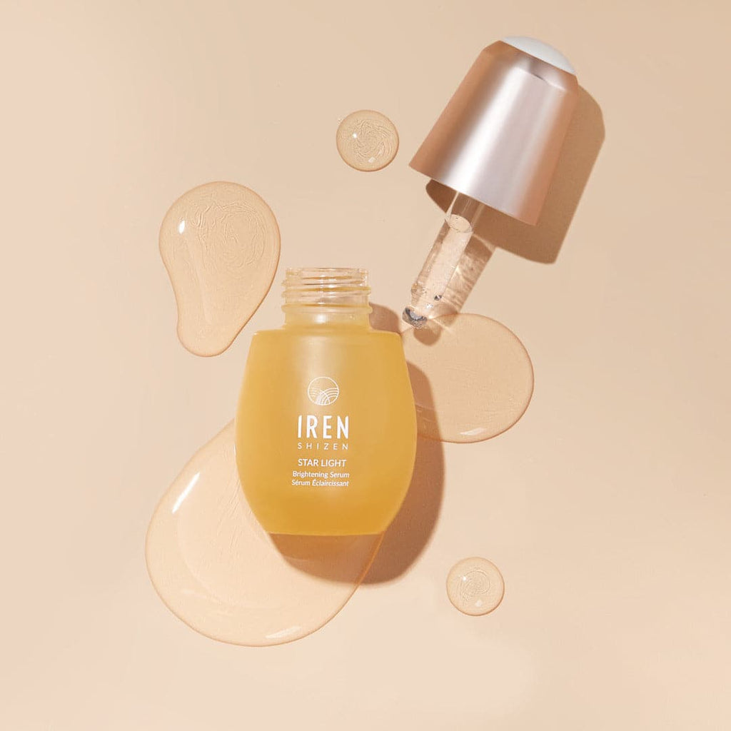 A customized GLOW UP Anti-Aging Set by IREN Shizen and a bottle of water on a beige background.