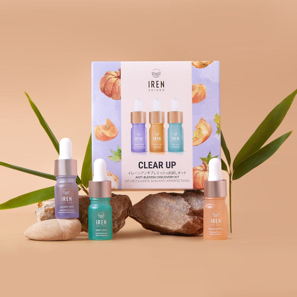 A set of IREN Shizen's CLEAR UP Anti-Blemish Discovery Kits, featuring customized Japanese skincare, placed on a rock.